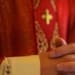 Sacerdote cattolico sullaltare in preghiera durante la messa