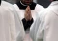 prete in preghiera con le mani giunte